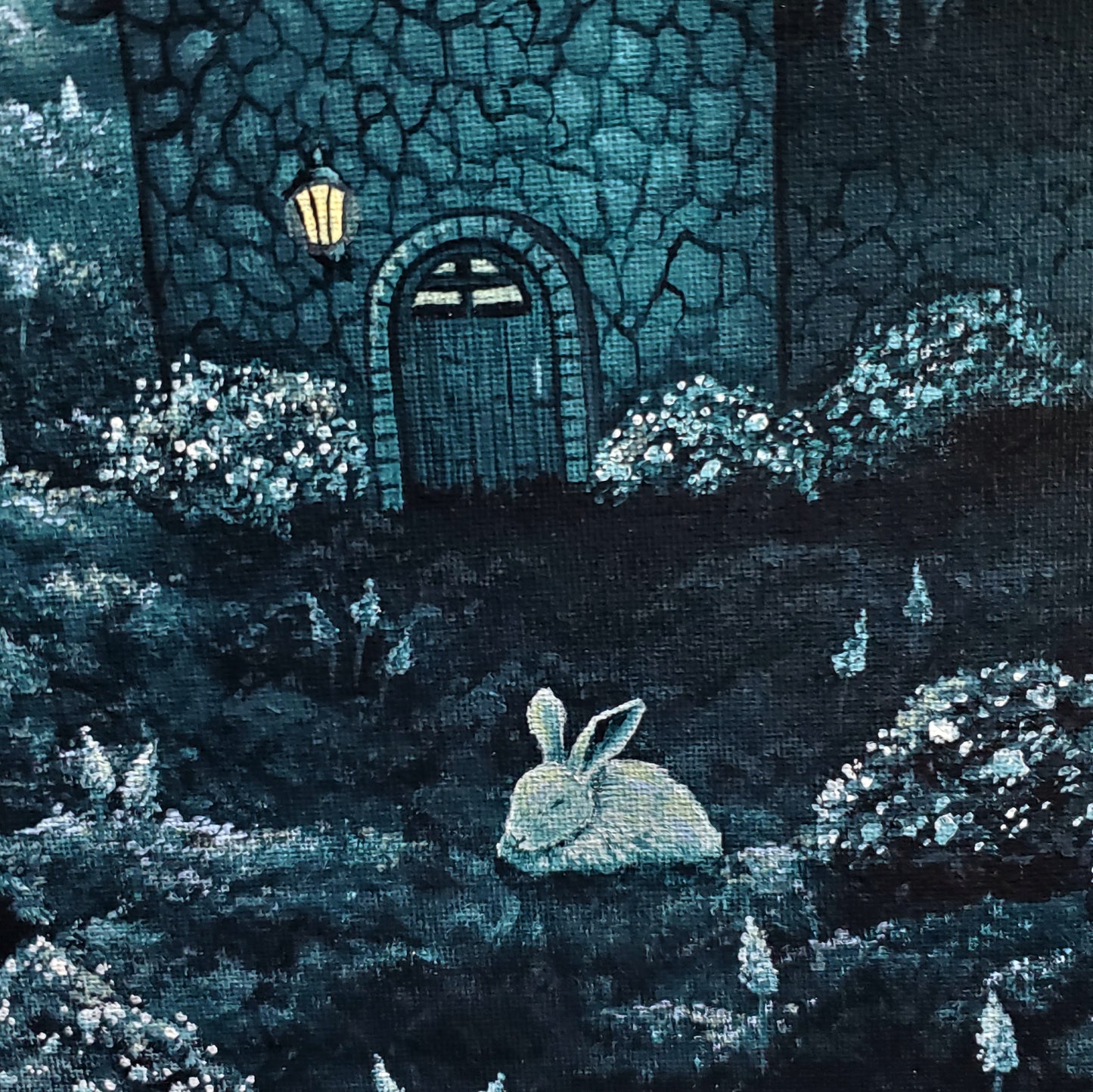 Close up of sleeping bunny and front door of the home. The grass is filled with hyacinth flowers and bushes