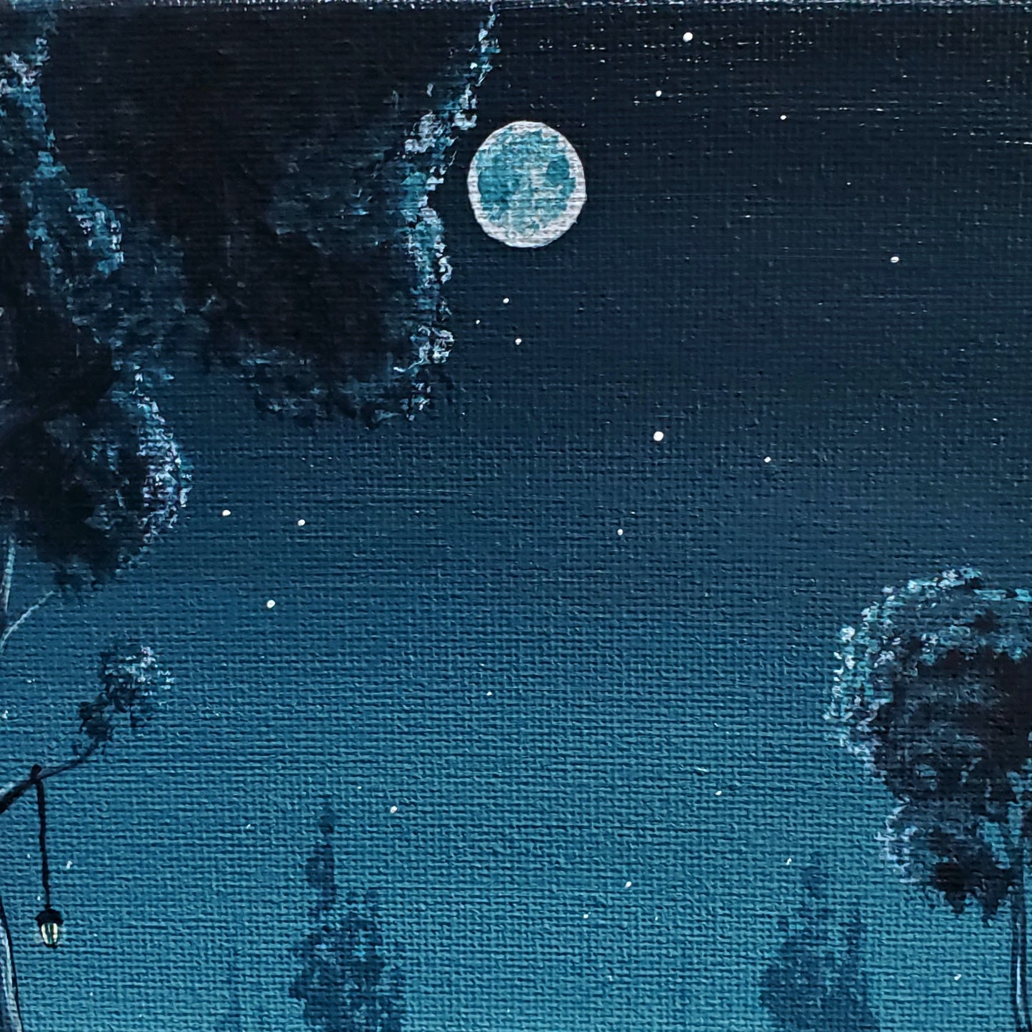 Close up of full moon, surrounded by stars and tree tops
