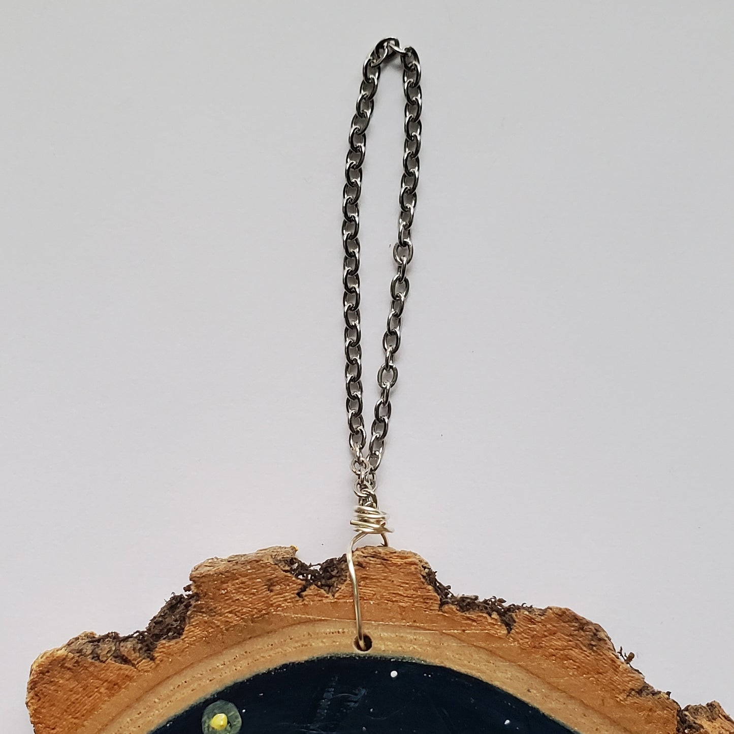 close up of chain, hangs on wall by tack or nail